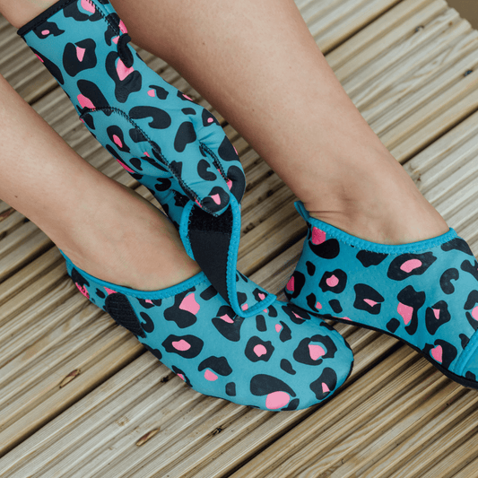 Blue leopard print neoprene beach shoes on a wooden floor