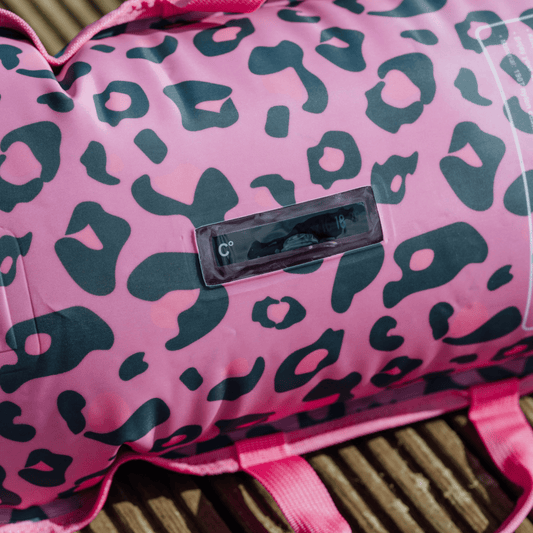 Pink inflated tow float with black leopard print pattern on a wooden surface