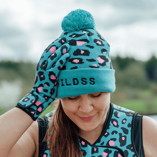 Person wearing a teal beanie with leopard print patterns outdoors