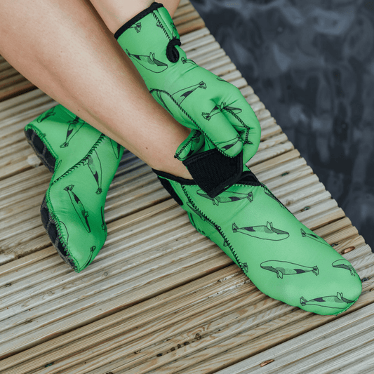 Green neoprene swimming boots with a velcro strap.