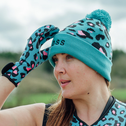 Person wearing a turquoise leopard print beanie and gloves outdoors