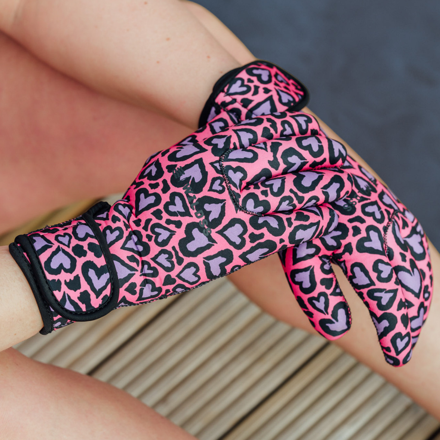 Pink and black leopard print neoprene glove on a person's hand