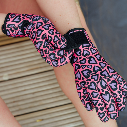 Pink and black leopard print neoprene glove on a person's hand with a blurred background