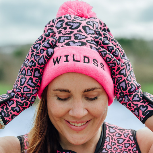 Person wearing a pink beanie with 'WILDS' logo