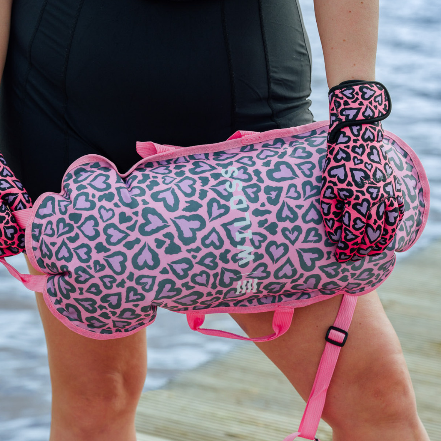 Pink and purple leopard print inflated tow float being held by a body of water