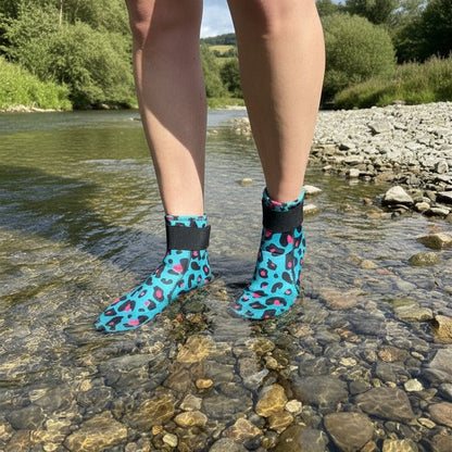 Person wearing turquoise leopard print neoprene swimming socks standing in a shallow river