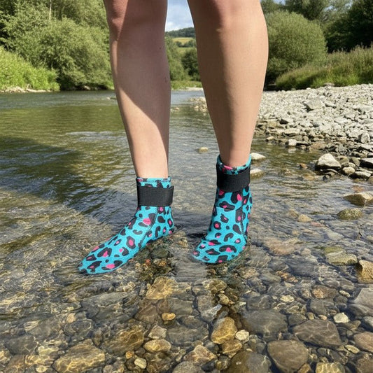 Person wearing turquoise leopard print neoprene swimming socks standing in a shallow river