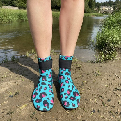 Person wearing turquoise leopard print neoprene swimming socks standing on a riverbank
