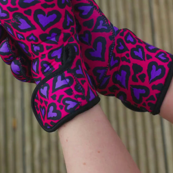 Video of woman wearing pink and purple leopard print neoprene gloves and removing them with the velcro wrist strap
