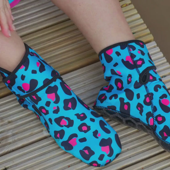 Video of woman wearing turquoise leopard print neoprene socks and removing them with the velcro ankle strap